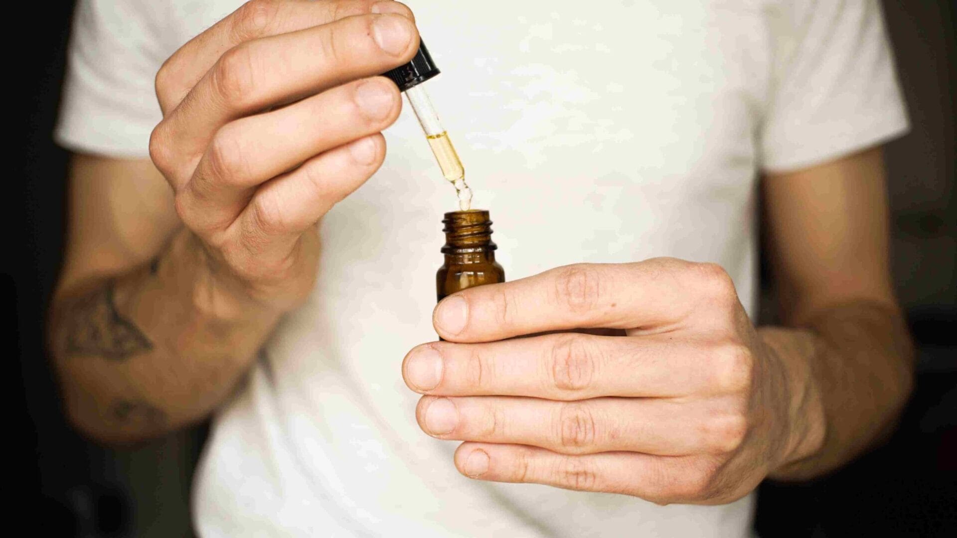 A man holding a dropper bottle of CBN oil in his hands